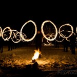 Performers swinging fire poi to the beating of drums